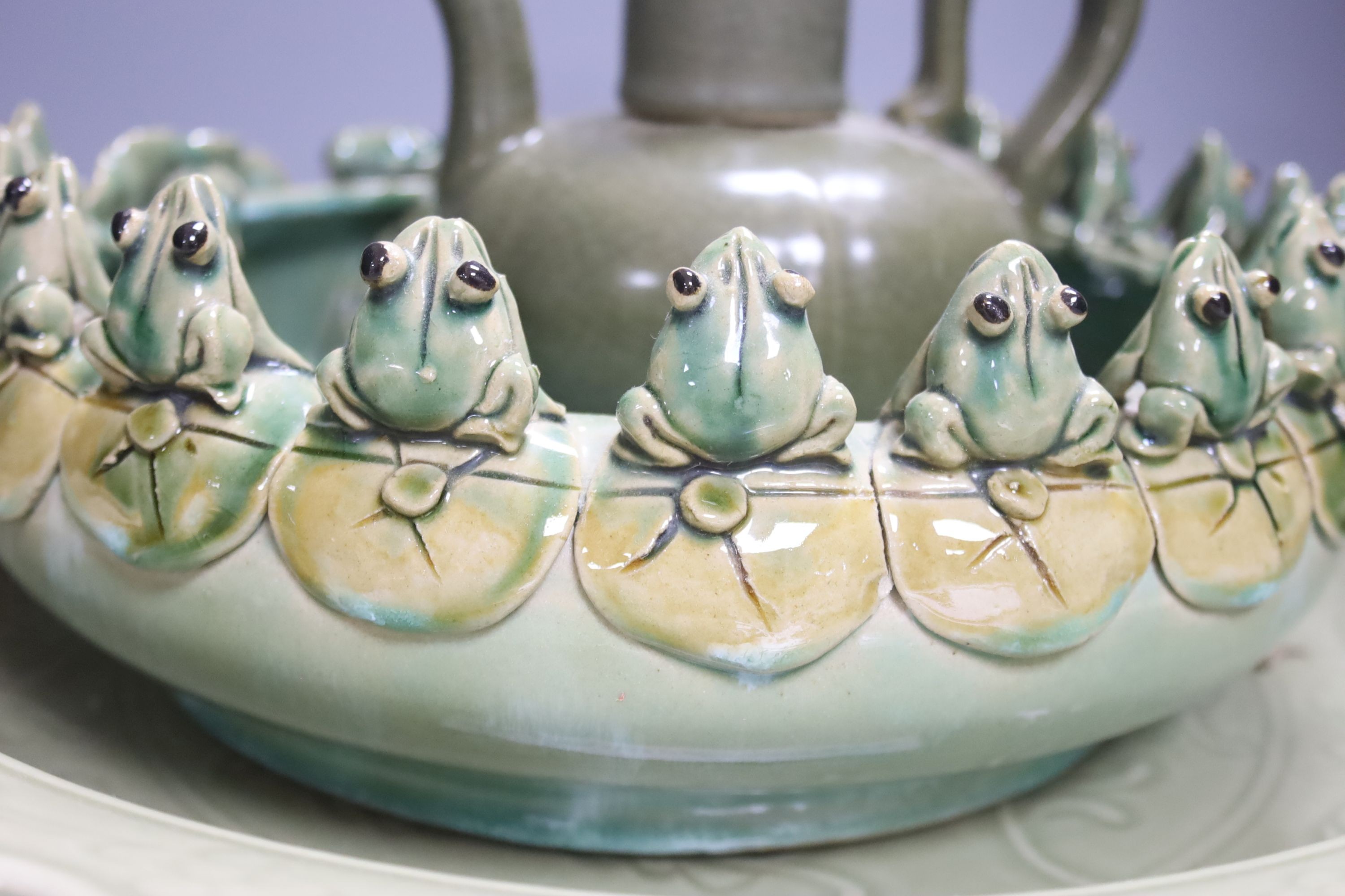 A large Chinese celadon glazed dish, a Chinese green crackle glaze ewer and cover and a 'frog pond' bowl (3)